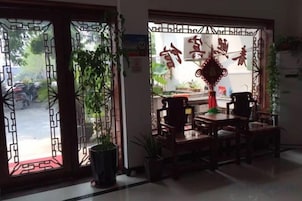 Una habitación con un portón chino tradicional, una mesa de comedor con sillas y vistas a la calle.