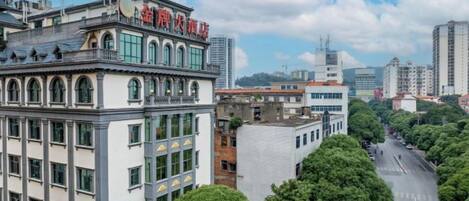 Un edificio de varios pisos con un estilo arquitectónico clásico, que presenta una entrada destacada y ventanas amplias.