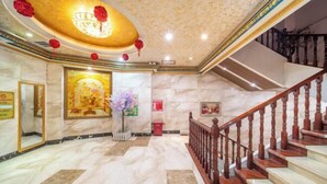 A marble-floored lobby with a staircase, a large framed artwork, and red floral decorations on the ceiling. - Jinpai Hotel (Baise Xiangyang) (Baise)