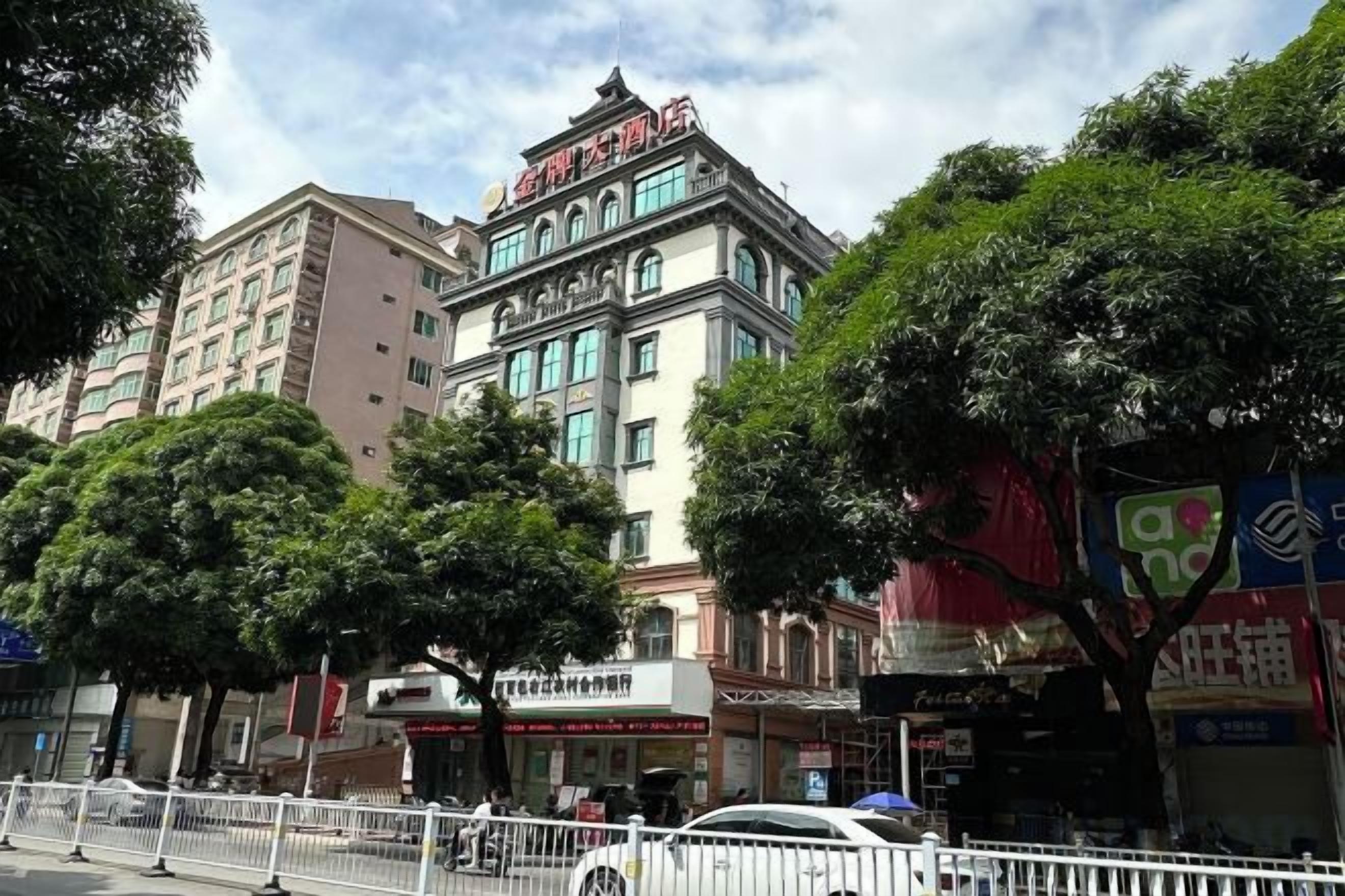 A multi-story hotel with a traditional architectural style, featuring a prominent entrance and signage.