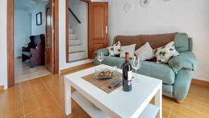 A living room with a green sofa, a white coffee table, and a bottle of wine. - 2 bedroom gorgeous home in Algodonales (Algodonales)