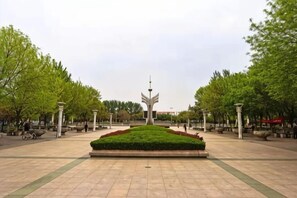 A public square with a central garden, pathways, and trees. - Shankee Hotel (Junan County Longshan Road) (Junan County)