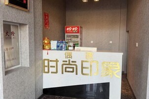 Un mostrador de recepción con un letrero que dice '时尚印象' (Fashion Impression).