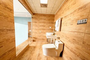 Un baño moderno con paneles de madera, inodoro, lavabo y espejo.