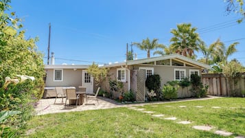 A residential property with a patio, outdoor seating, and a fenced yard.