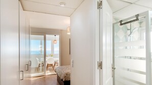 A modern hotel room with a balcony, a bed, and a shower area. - Magic of the ocean, Front Line Beach Apartment (TORREMOLINOS)