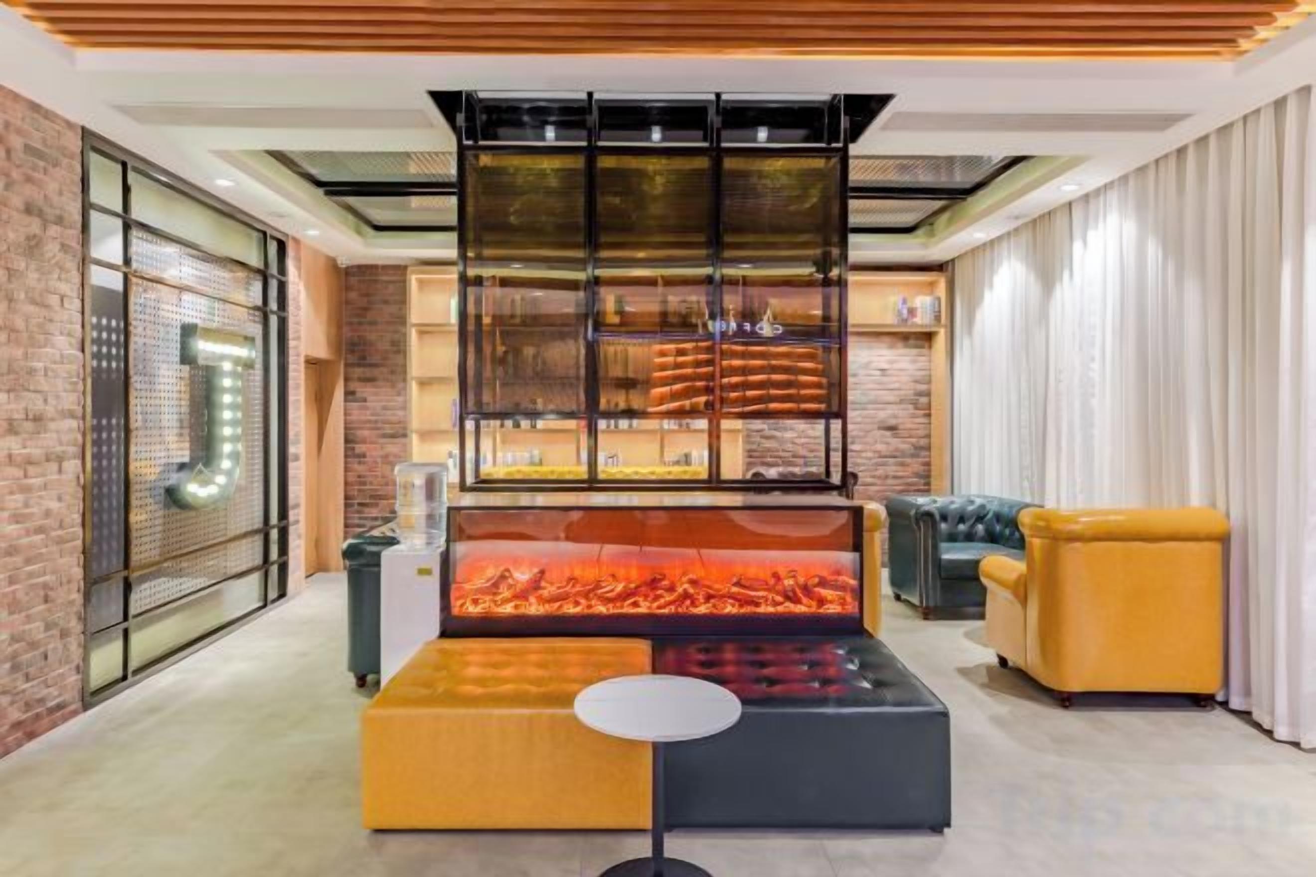 A modern interior with a fireplace, seating area, and a glass partition.