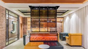 A modern interior with a fireplace, seating area, and a brick wall. - Shexian Huizhou Gucheng store JAMES JOYCE COFFETEL (She County)