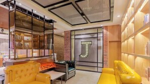 A modern interior with a fireplace, leather sofas, and a bookshelf with a large illuminated 'T'. - Shexian Huizhou Gucheng store JAMES JOYCE COFFETEL (She County)
