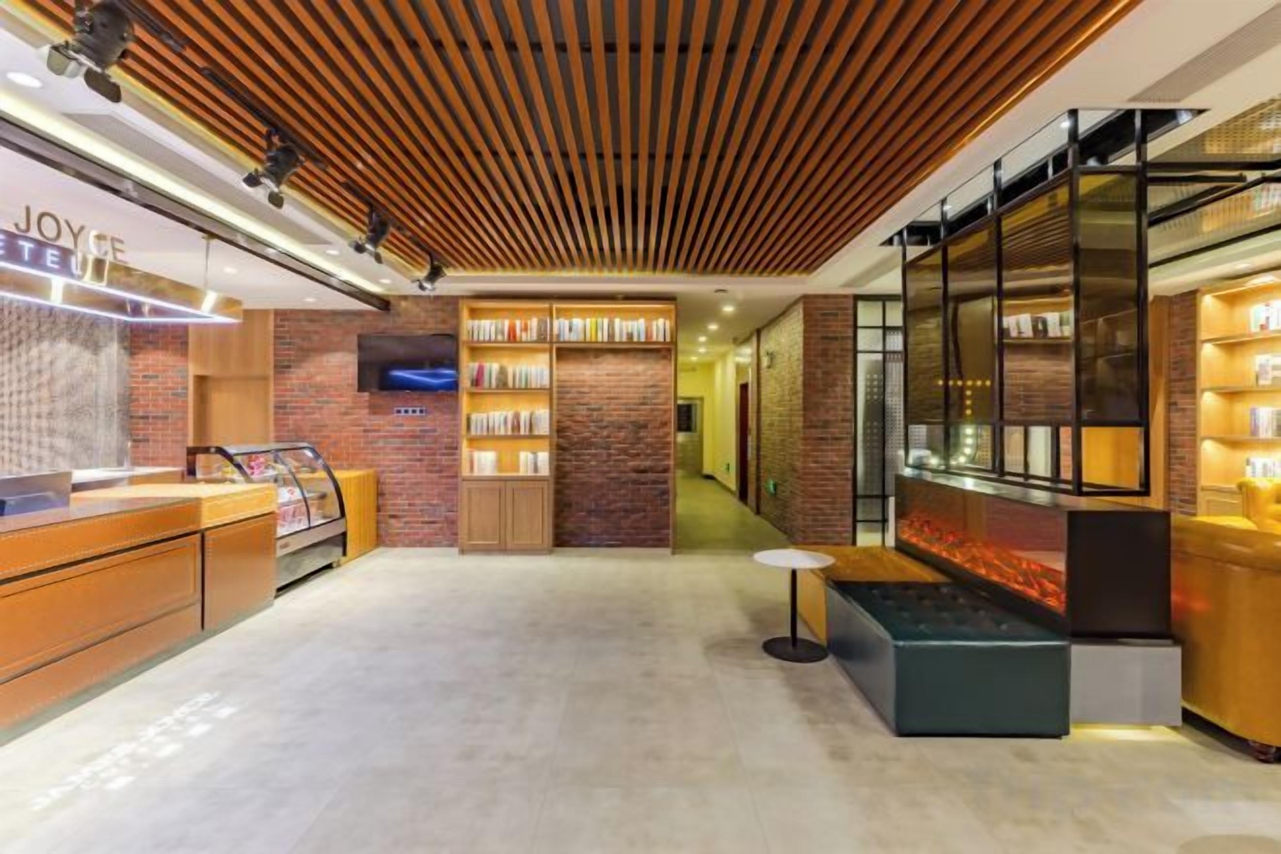 Un hall d’hôtel moderne comprenant un comptoir d’accueil, un espace salon et un présentoir de produits.