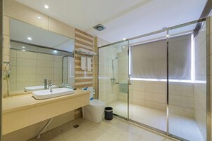 Un baño moderno con dos lavamanos, un espejo grande y cabina de ducha con paredes de vidrio.