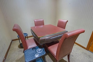 A small dining area with a table and four chairs, a small side table with a cup and a bowl, and a patterned carpet. - Home Inns in Liushi Yueqing (Yueqing)