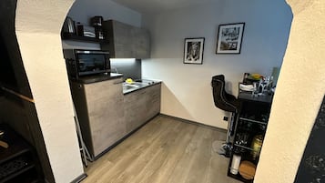 Cafetera o tetera, frigorífico, horno y placa de cocina