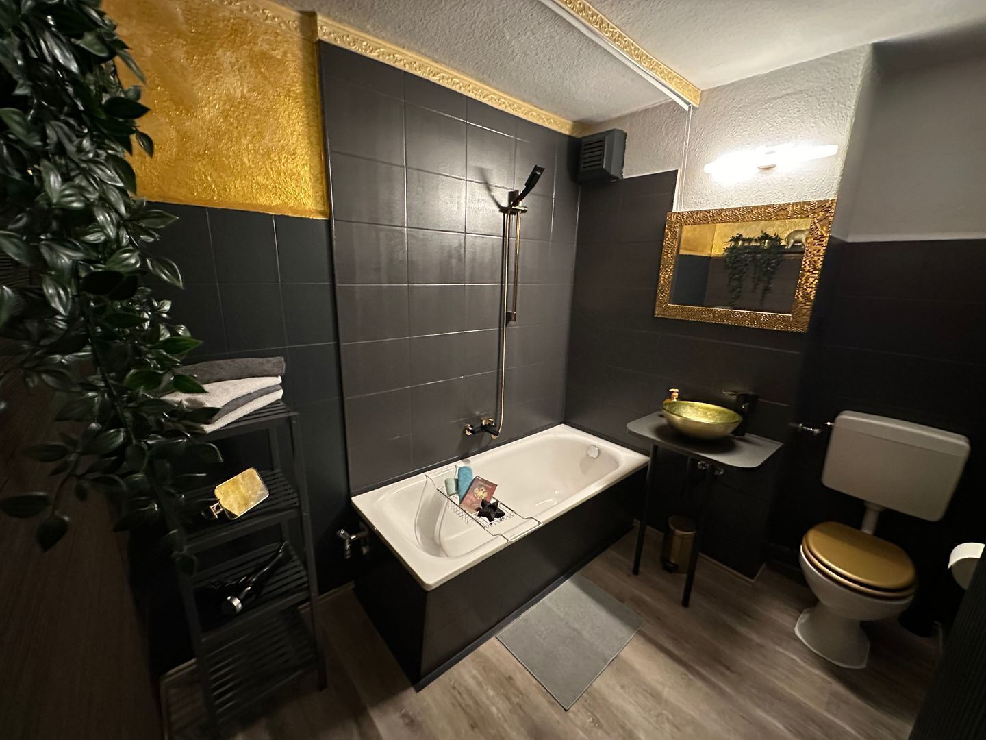 Een moderne badkamer met bad, wastafel, toilet en een grote spiegel.