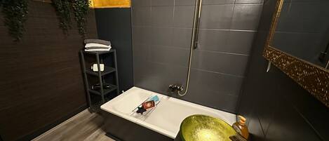 A modern bathroom with a bathtub, a shower, and a sink.