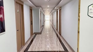 A hotel corridor with doors on both sides, a marble floor, and a sign indicating room numbers 501 and 519. - 99inn Selected Preferred Hotel (Shanghai Fengjing Ancient Town) (Shanghai)