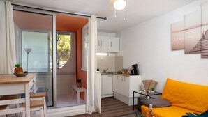 A compact living space with a kitchen, a dining area, and a sofa. - Les Marquises by Interhome (La Grande Motte)