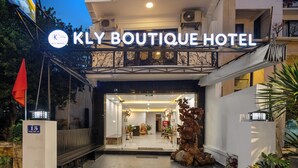 Entrada do KLY Boutique Hotel, com design moderno, uma varanda e uma grande escultura decorativa na parte externa.