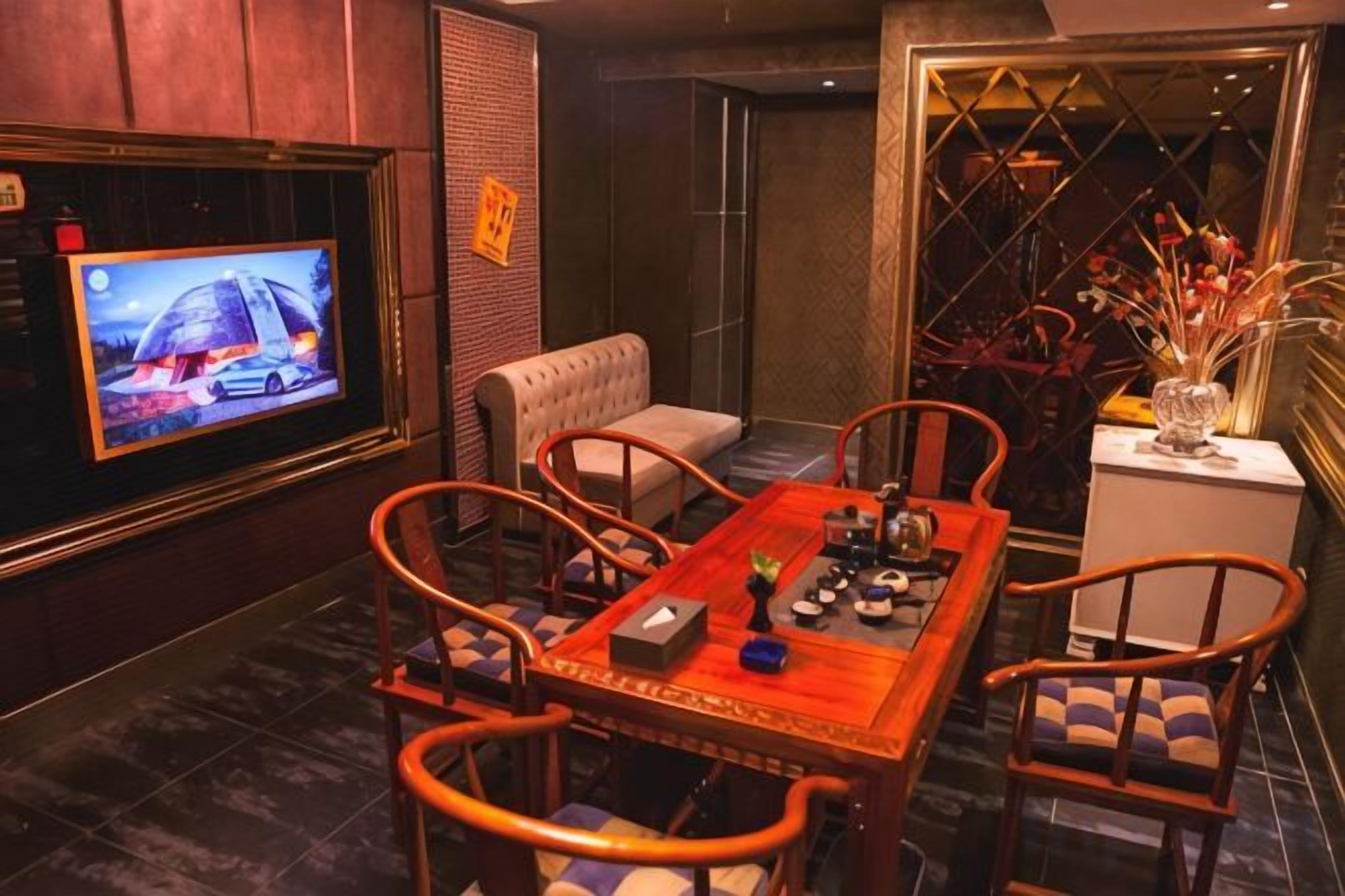 A dining area with a television, a table, chairs, and a decorative vase.