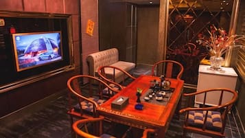 A dining area with a television, a table, chairs, and a decorative vase.
