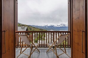 A balcony with two folding chairs and a view of snow-capped mountains. - Tramway - Appart Vue 180° | Parking | 5mn Centre & Remontées (Saint-Gervais-les-Bains)
