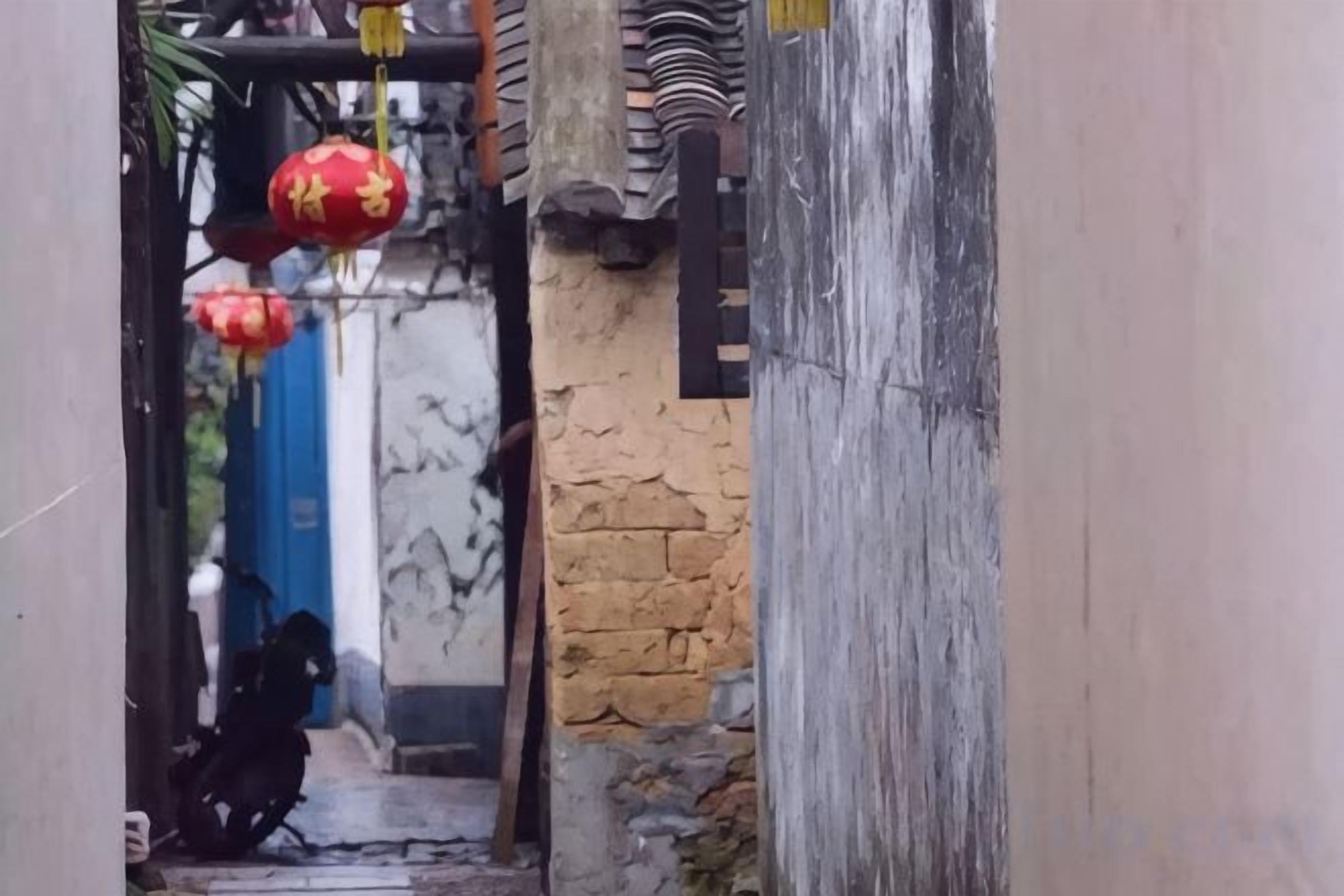 Un callejón estrecho con una motocicleta estacionada al final.