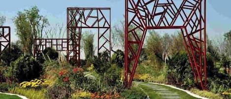 A garden with red metal structures and a stone pathway.