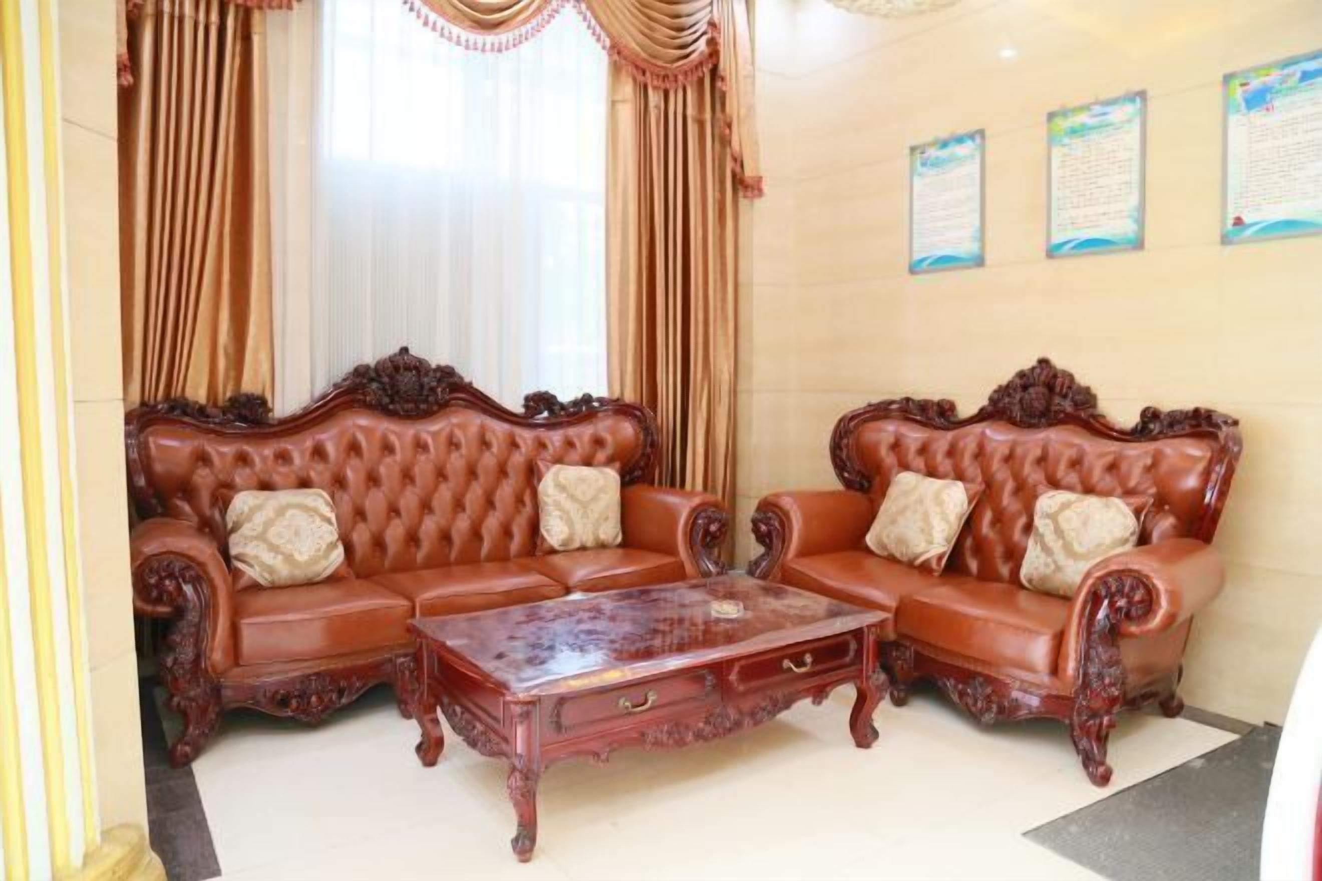 A room with two ornate sofas, a wooden coffee table, and curtains.