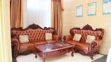 A room with two ornate sofas, a wooden coffee table, and curtains.