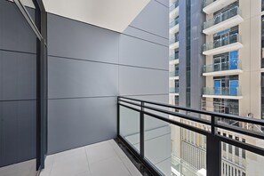 A modern building with a glass balcony and a view of other buildings.