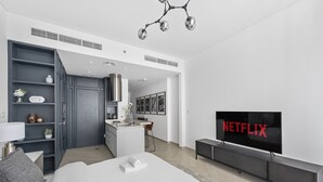 Quarto de hotel moderno com cama, televisão, cozinha compacta e closet espaçoso.