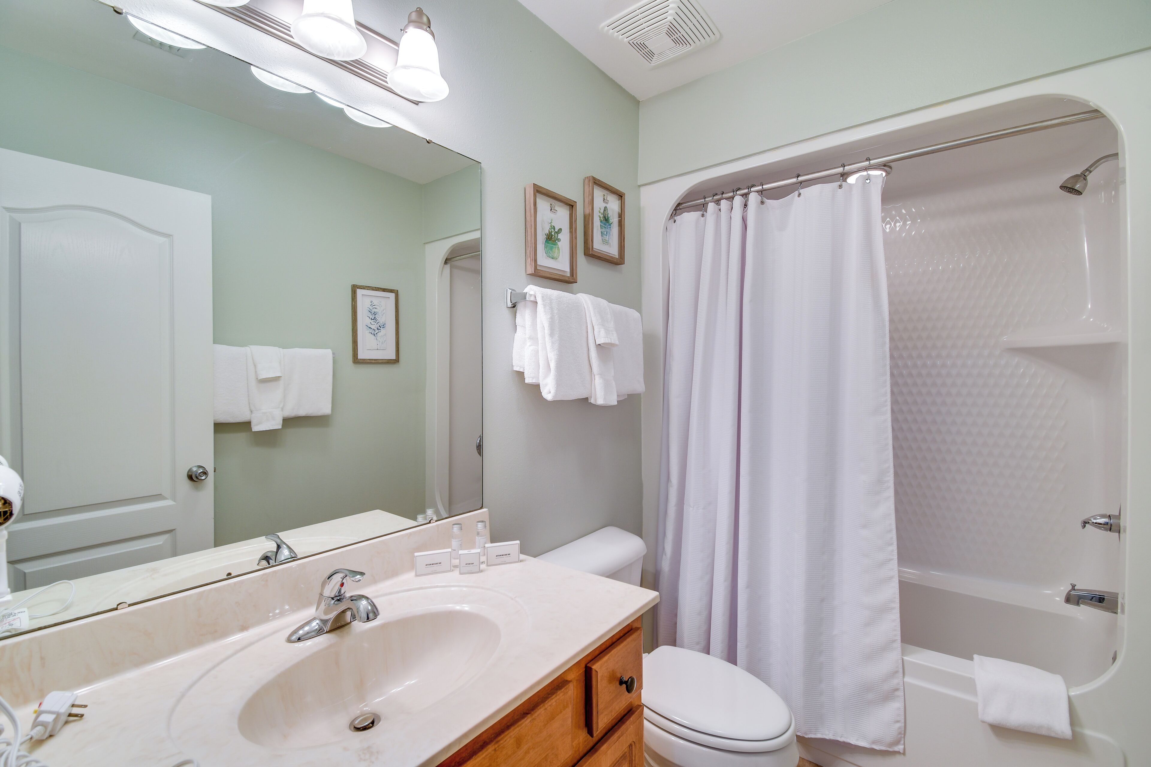 Une salle de bain équipée d’un lavabo, d’un miroir, de toilettes et d’une douche.
