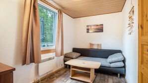 Ein Zimmer mit Fenster, einer Couch, einem kleinen Tisch und einer Heizung.