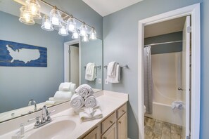 Une salle de bain équipée d’un lavabo, d’un miroir et d’un porte-serviettes.