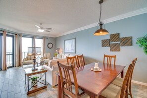 Un espace repas comprenant une table en bois, des chaises et un ventilateur de plafond.