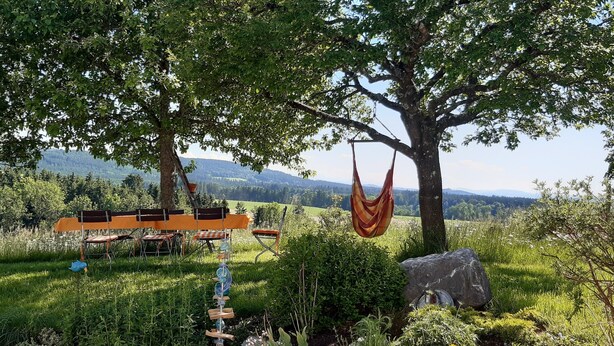 A hammock hanging from a tree, a wooden bench, and a view of a mountainous landscape. - Apartment 'Ferienwohnung Birke' with Mountain View, Private Terrace and Wi-Fi (Altusried)