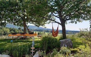 A hammock hanging from a tree, a wooden bench, and a view of a mountainous landscape. - Apartment 'Ferienwohnung Birke' with Mountain View, Private Terrace and Wi-Fi (Altusried)