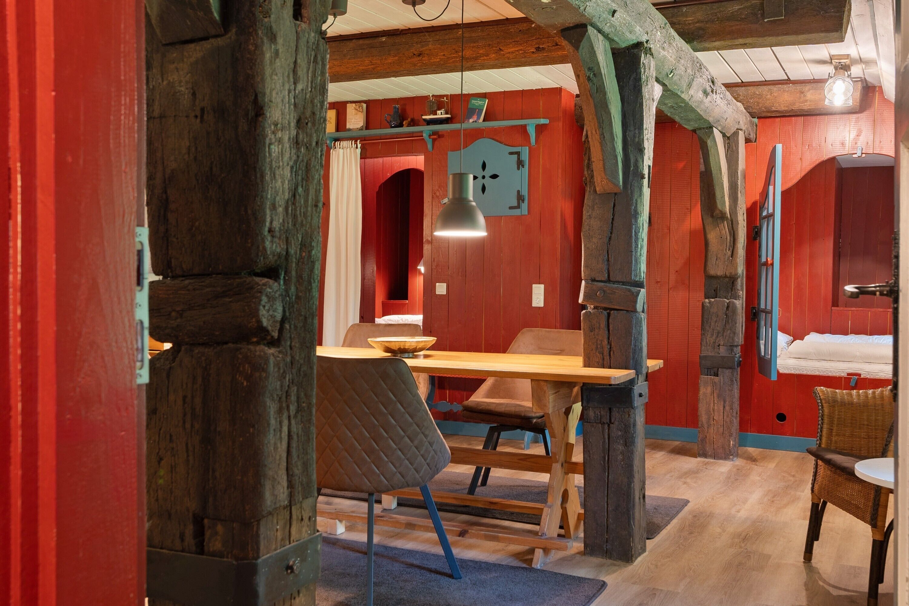 Une pièce rustique avec des poutres apparentes, une table en bois et une chaise.