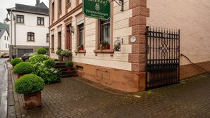 A building with a sign reading 'Eulenhof Ferienwohnungen Hubert Fielen' and a black wrought iron gate. - Apartment 'Eulennest 1' with Private Terrace and Wi-Fi (Minheim)