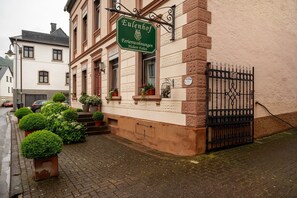 Un bâtiment avec une enseigne indiquant « Eulenhof Ferienwohnungen Hubert Fielen » et un portail en fer forgé noir.