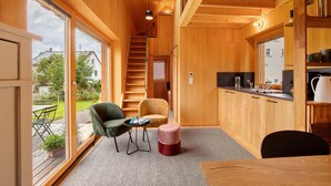 Un interior de madera con una escalera, un comedor y una cocina.