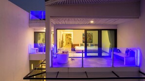 A modern hotel room with a balcony, a large bed, a seating area, and a bathroom. - Master Peak H4 - 2BR Villa at Bang Rak Beach (Bo phut)
