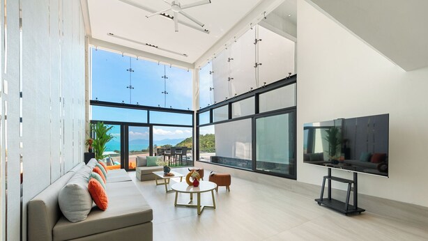 A spacious living area with a large TV, comfortable seating, and a view of the ocean. - Master Peak H4 - 2BR Villa at Bang Rak Beach (Bo phut)
