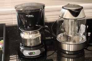 A coffee maker and a glass carafe on a kitchen counter.