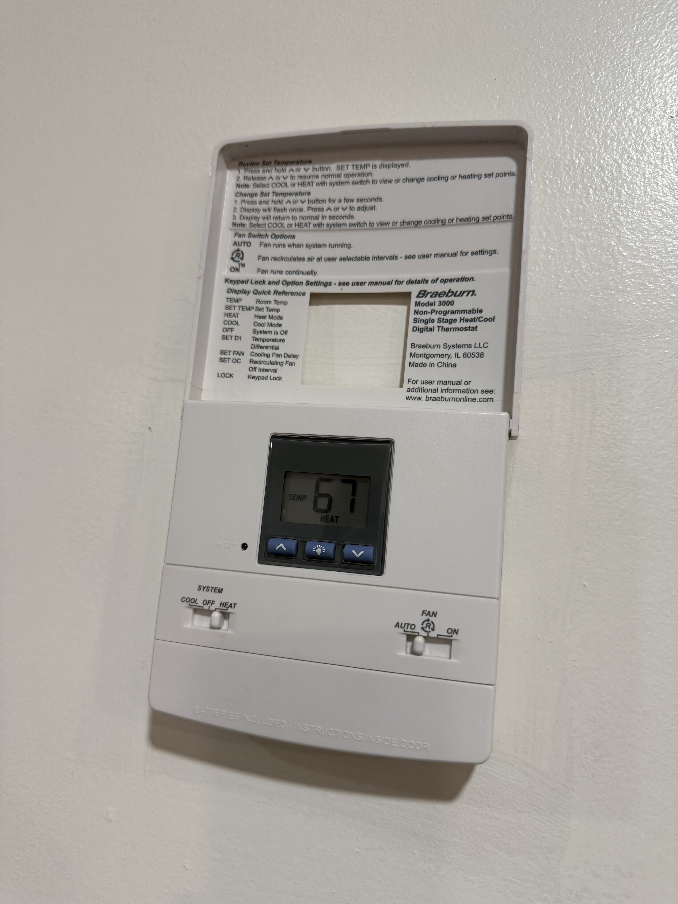 Un termostato con pantalla digital que muestra 67 grados.