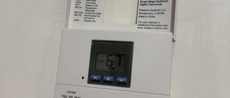 Een thermostaat met een digitaal display waarop 67 graden wordt aangegeven.