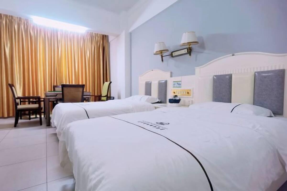 Ein Hotelzimmer mit zwei Betten, einem Schreibtisch und einem Stuhl.