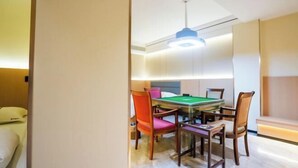 Une pièce équipée d’une table de billard, de chaises et d’un luminaire au plafond.