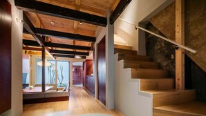 A modern interior with a wooden staircase, a glass railing, and a tiled floor. - Akeiro Machiya House (Kyoto)