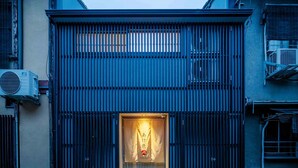A building with a large, dark entrance gate and air conditioning units on the sides. - Akeiro Machiya House (Kyoto)
